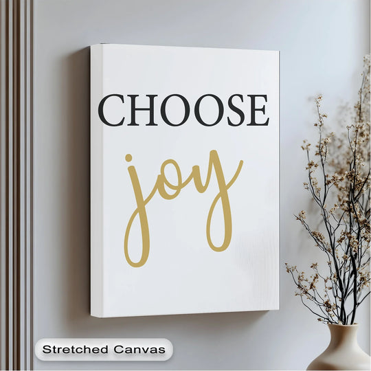 Subtle, vertical wall paneling and delicate floral accents create a serene backdrop for this inspirational 'Choose Joy' canvas artwork print.