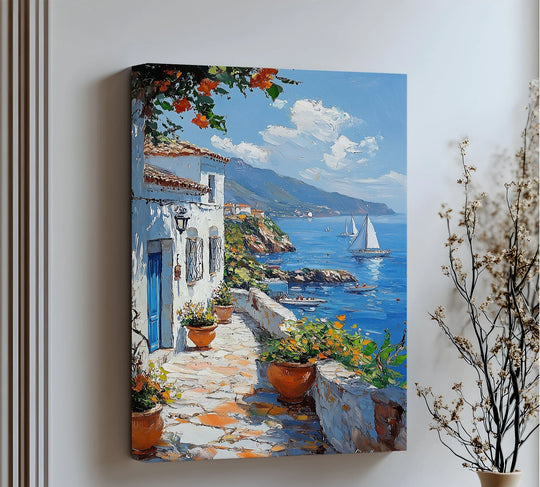 Sunlight illuminates the brightest area of the Mediterranean Stroll canvas artwork, capturing a serene seaside village path with a blue door and vibrant floral accents.