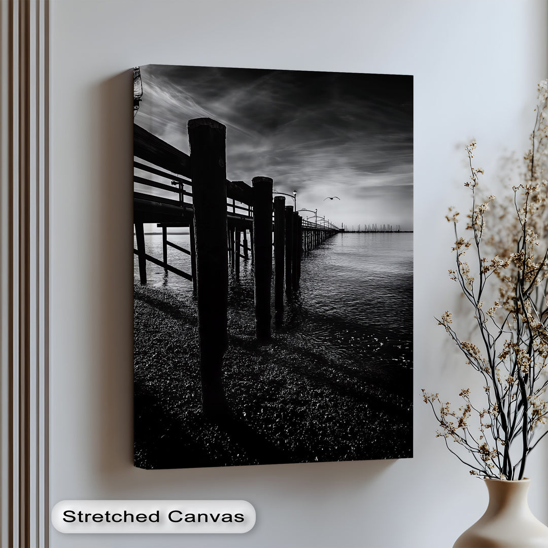Embrace moody elegance with this striking canvas wall art of a shadowed pier and still waters.

