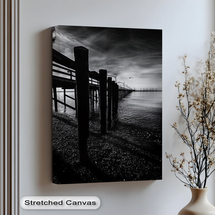 Embrace moody elegance with this striking canvas wall art of a shadowed pier and still waters.

