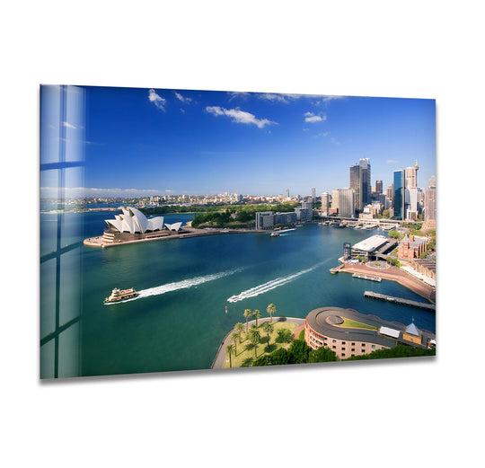 Capturing the essence of Sydney Harbour, the brightest area in this glass wall art highlights the iconic Opera House within this vivid glass art painting, set against the cityscape and blue sky.