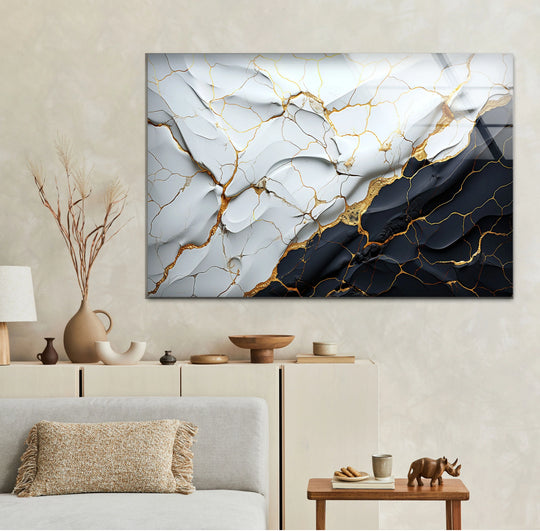 Abstract glass wall artwork features sharp geometric lines and angular shapes in a black and white marble design with golden accents.