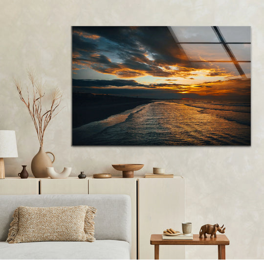 The glassy sheen of golden sunset ocean wall art accentuates the sense of movement as twilight ripples across this moody coastal landscape in this glass art painting.