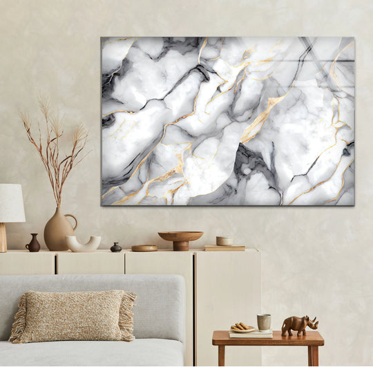 A modern glass wall artwork features a low color saturation abstract design of white marble with subtle gray and gold veins.