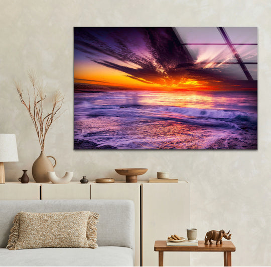 Layering hues of purple and orange create depth in this vibrant ocean sunset hanging wall art, showcasing the sky and waves glass print.