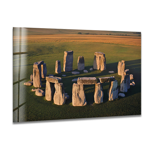 Illuminated ancient stones stand out as the loudest element in this Stonehenge aerial view glass wall art, a piece of unique modern wall decor capturing the iconic ancient wonder.