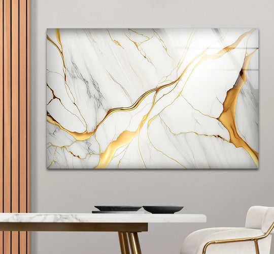 A sophisticated abstract glass wall art decor with dark grey veins and flowing gold accents on white marble.