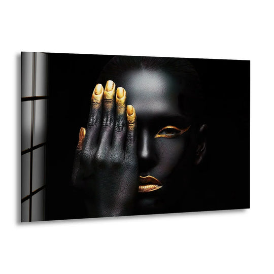 Glass wall art showing a woman with black and gold skin and gold hands is bold woman wall decor and cool art