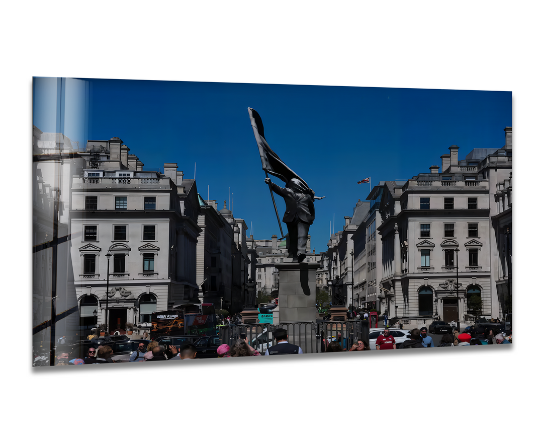 The vast, clear blue negative space of the sky frames a striking Banksy statue in London, creating compelling art from glass.