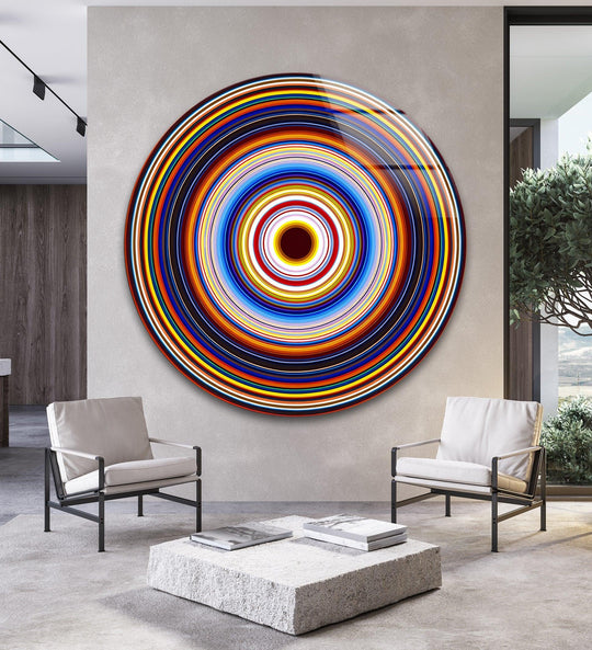 The concentric circles of this round glass hanging wall art seem to spin outward, drawing the eye into a vibrant display of motion and color.