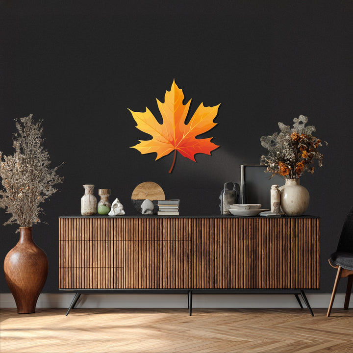 Against a textured black background, the golden autumn maple leaf decorative metal art accentuates modern fall decor.