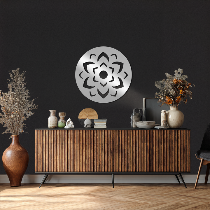 Foreground shows the sleek, modern console table against a textured black wall, complemented by decorative metal art in the shape of a lotus mandala.