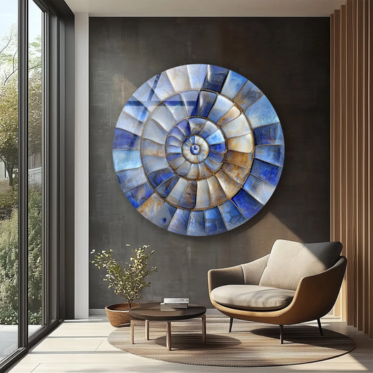 Geometric tile patterns radiate in a spiral from the center of this coastal-inspired round glass hanging wall art, blending blue and amber hues.