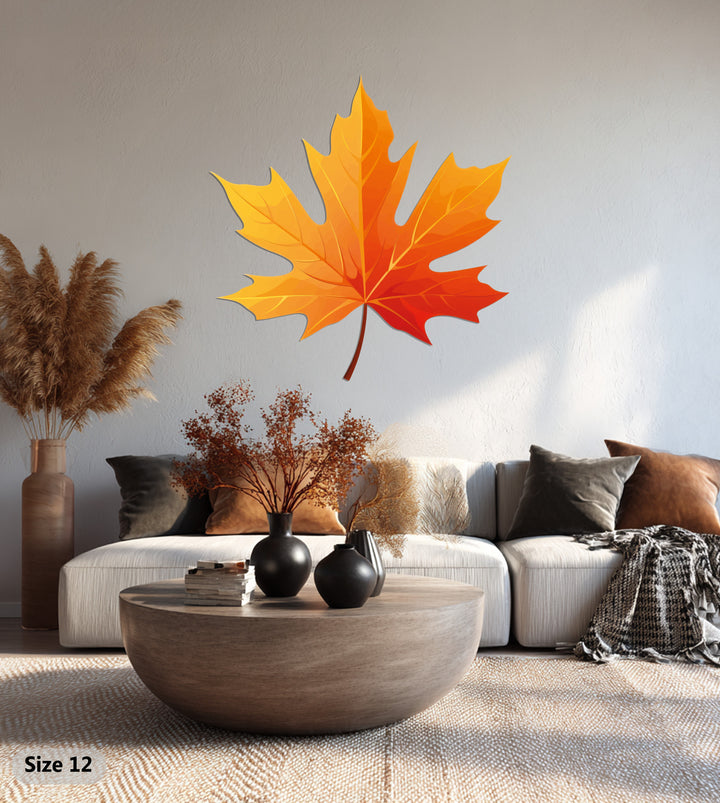 Featuring foreground detail, a round wooden coffee table and plush woven rug complement the Golden Autumn Maple Leaf metal wall decor, showcasing modern metal art.