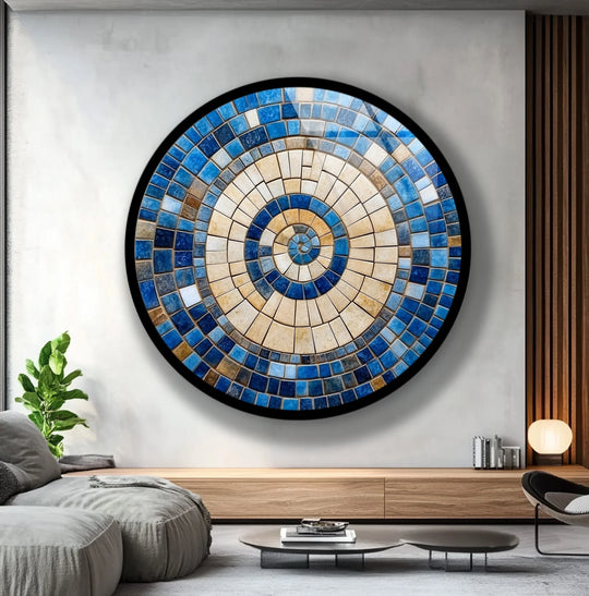 Negative space surrounds this circular glass art painting, emphasizing its sunburst design with beige and blue mosaic tiles.
