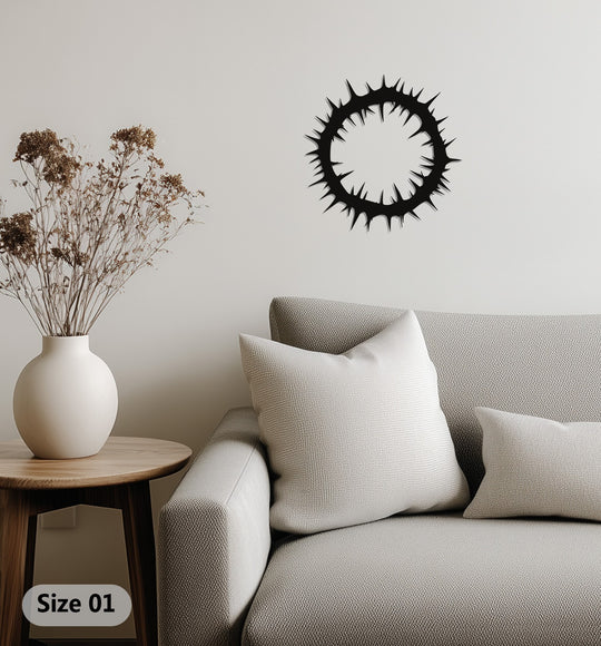Layered shadows emphasize the depth of the Crown of Thorns, a metal decoration wall art piece mounted above a neutral couch with soft pillows.