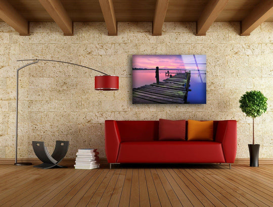 Illuminated by the vibrant sunrise, the sky glows in this tempered glass wall art featuring an abandoned dock, casting the brightest light on the tranquil water.