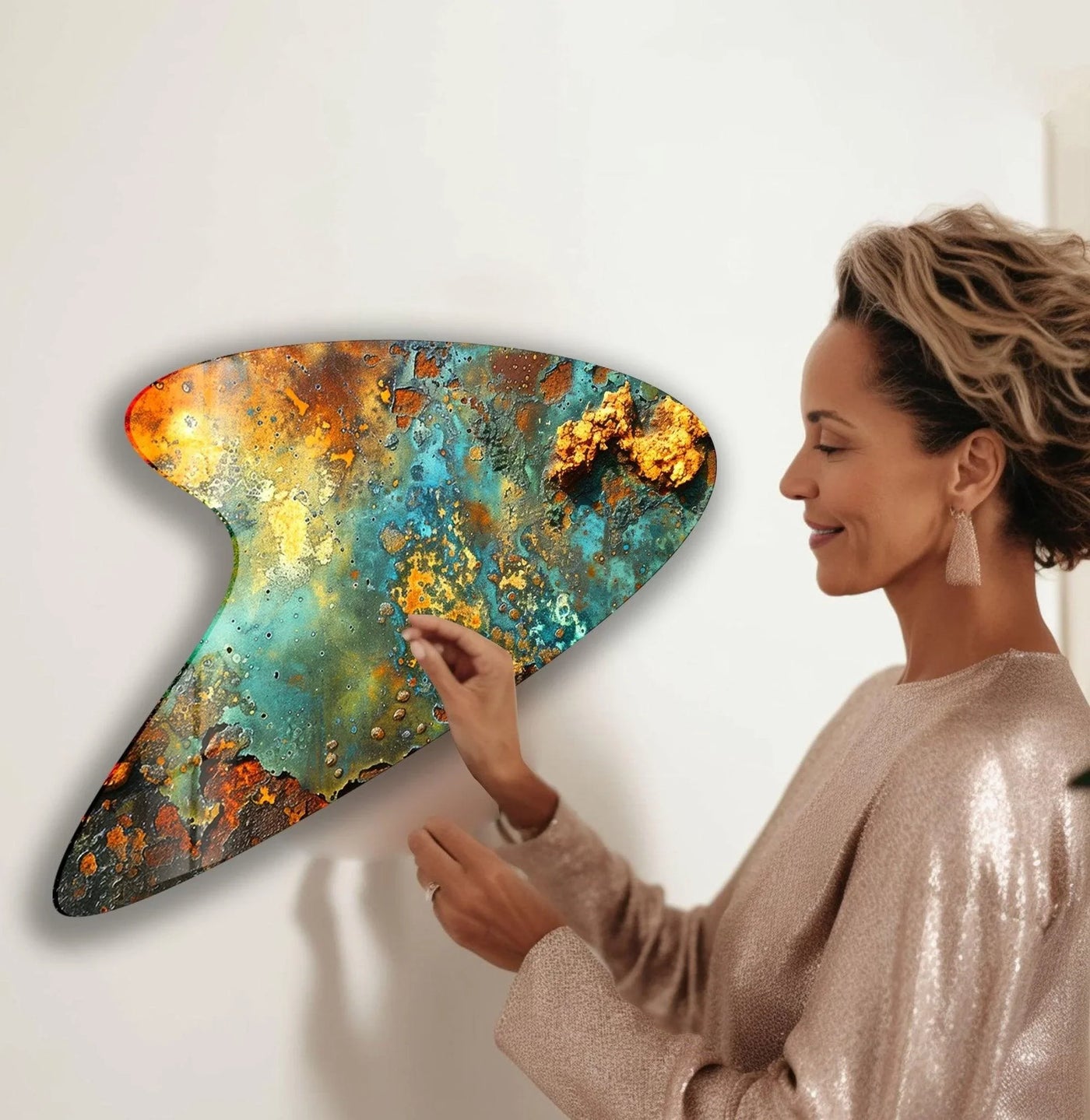 A woman admires the soft, ethereal glow of abstract green wall art prints with iridescent textures.