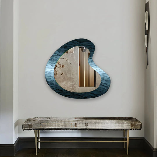 An Abstract Blue Asymmetrical Wall Mirror an elegant asymmetrical mirror with a blue wave motif reflecting a bright interior on a white wall