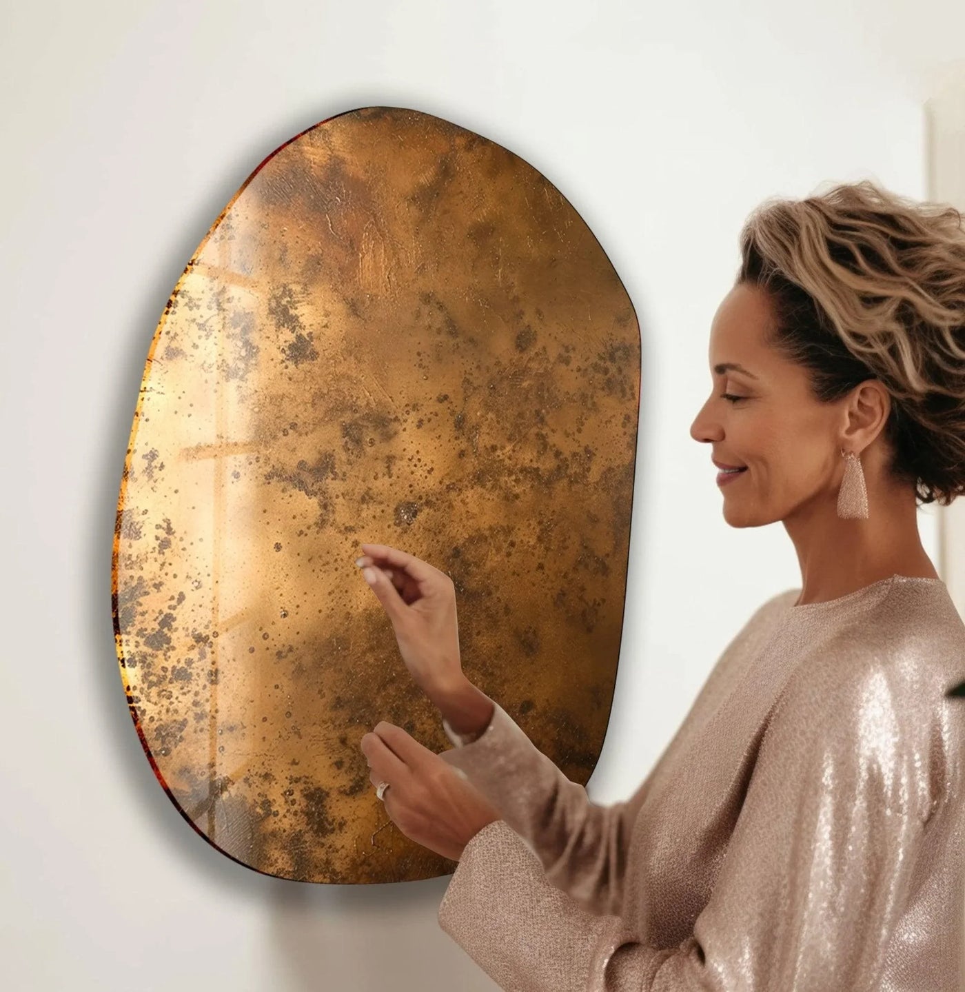 A woman in a sparkling dress touches an abstract copper oval glass wall art, adding home decor elegance.