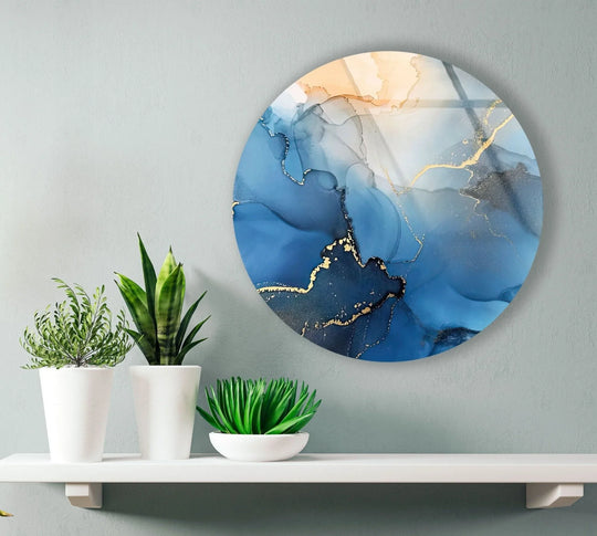 Fluid patterns of blue and gold give a sense of motion to the abstract round glass wall art prints, creating an eye-catching and modern decorative accent.