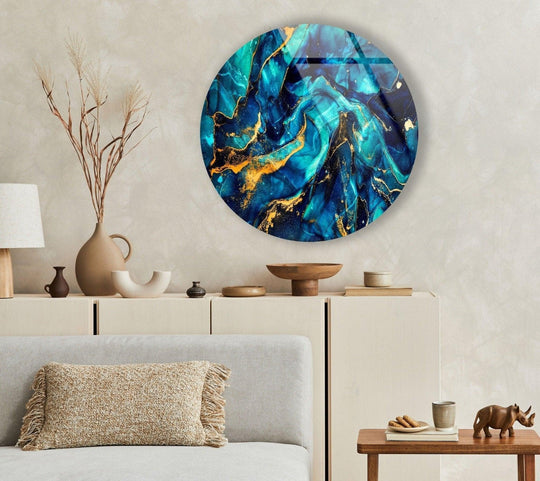 The brightest area showcases azure and teal hues swirling across the abstract round dark blue and gold glass wall artwork, creating a luminous effect.