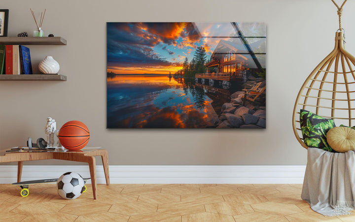 Large glass wall art of a cozy log cabin reflecting on a calm lake.
