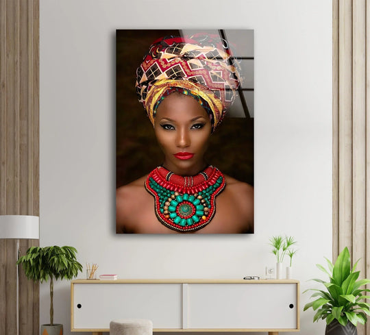 A striking African woman wearing a vibrantly patterned headwrap and a large, colorful beaded necklace is featured in this print wall art.