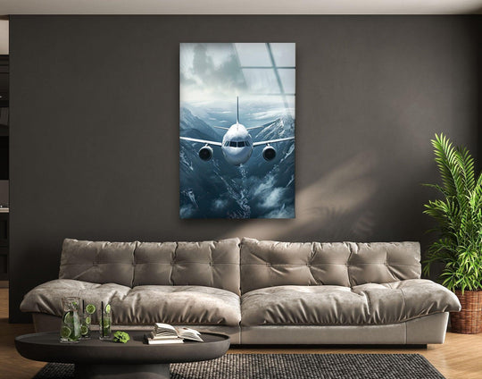 A commercial airplane flies through a cool-toned, cloudy sky over snowy mountains, depicted in this stunning wall print.