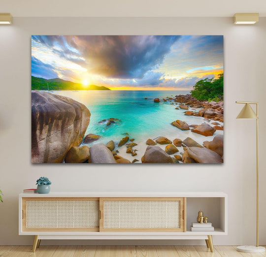 Illuminated by the sun, this Anse Lazio landscape tempered glass wall art features the beach's vibrant turquoise waters meeting the sandy shore near rocky formations.