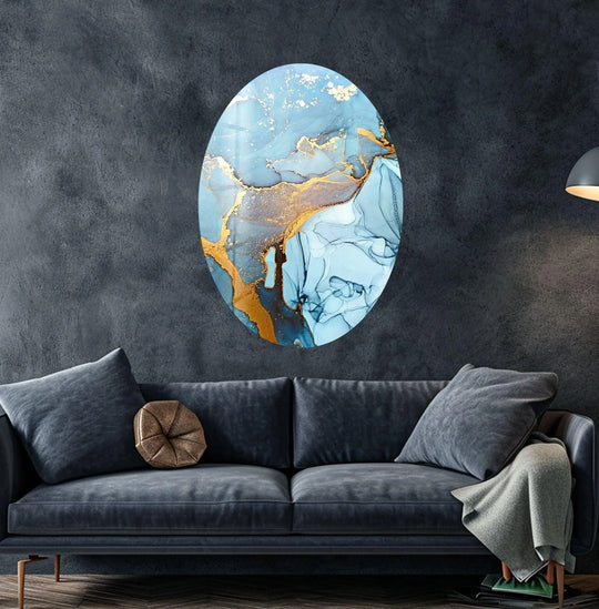 This oval abstract glass wall artwork showcases a glossy, marbled finish with striking gold and deep blue accents.