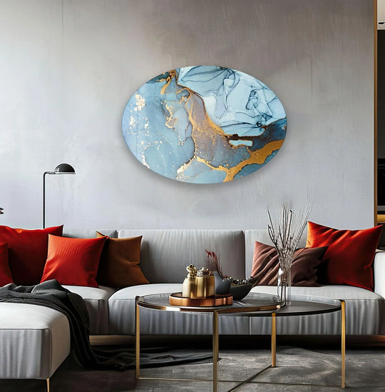 Asymmetric oval blue marble abstract glass wall art prints with gold accents grace a modern living space.