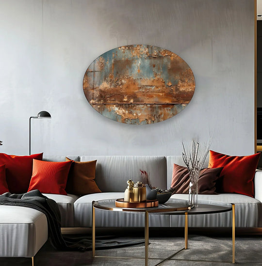 A round, rusty metal and glass wall art with peeling paint textures and visible rivets sits on a grey wall.