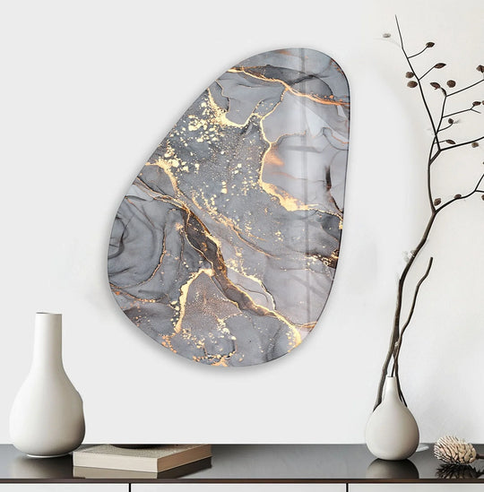 A glass printing showcases rich, saturated greys with striking metallic gold accents, creating a luxurious abstract oval design.