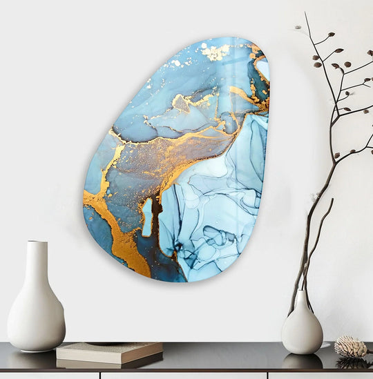 An abstract blue and gold glass wall art decor piece evokes a serene and luxurious mood with its fluid, marbled design.
