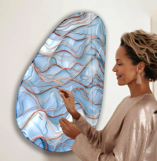 A woman admires abstract asymmetrical wall prints with flowing navy and gold lines on a white background.