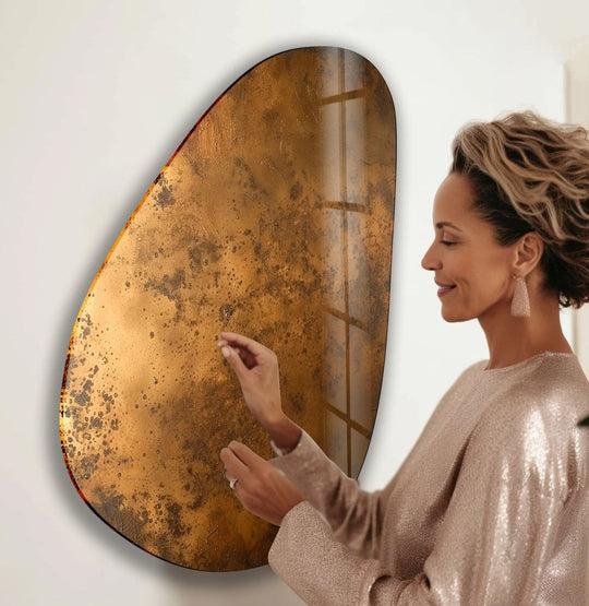 A woman in a sparkling dress interacts with an abstract oval bronze glass art piece, creating a captivating visual rhythm.