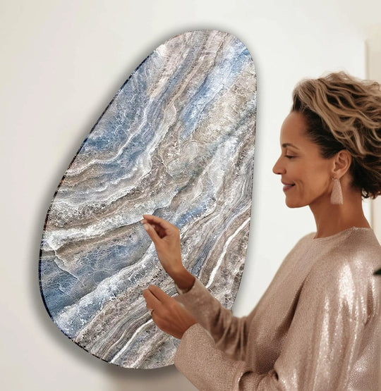 A woman admires a unique decorative wall art piece featuring bright, swirling abstract marble patterns.