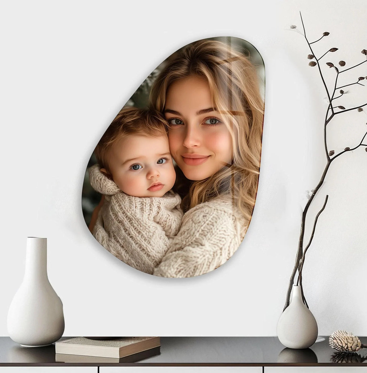 An abstract teardrop custom glass art piece features a loving mother holding her baby, creating personalized art prints.