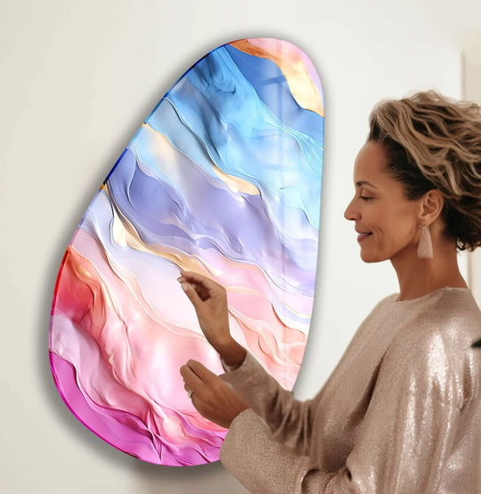 A woman admires asymmetrical oval rainbow abstract glass wall art, focusing on the brightest iridescent and pink swirled sections.