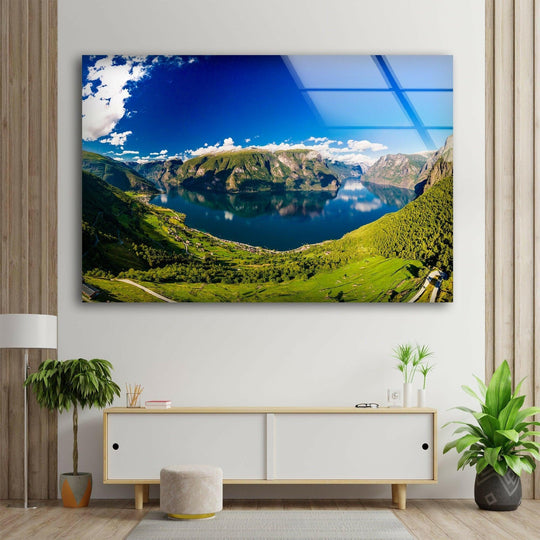 Blue skies and fluffy clouds give a soft touch to the breathtaking Aurlandsfjord landscape glass art painting, offering a stunning mountain view.