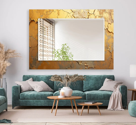 A gold abstract cracked wall mirror with a textured frame reflecting a window and plant adding elegant modern decor