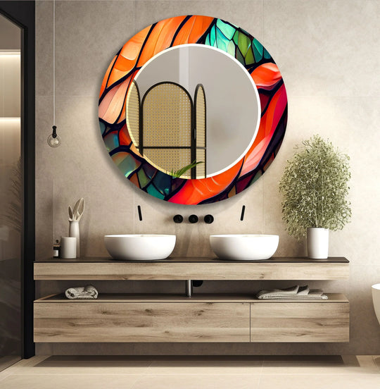 The round mirror is orange and green with a stained glass motif and it is colorful vibrant modern wall decor and a round mirror for the wall