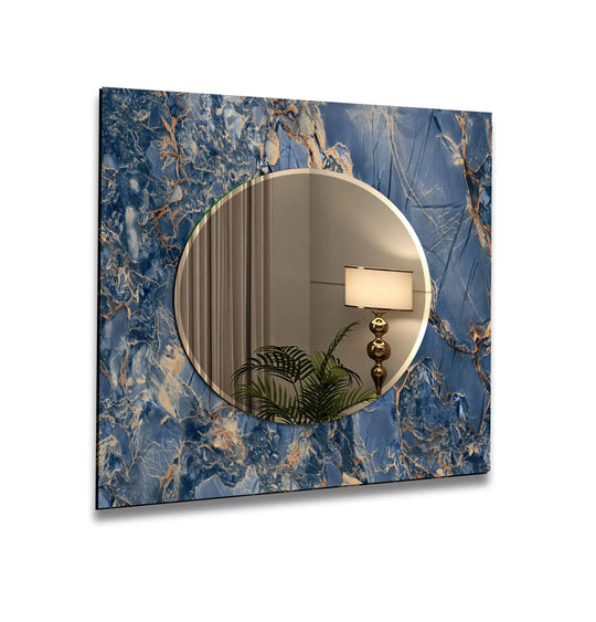 A decorative wall mirror with a navy blue and gold marble ceramic design on tempered glass reflecting a lamp and plant