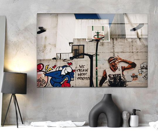 Banksy Graffiti Art Glass Wall Art shows a basketball player and street art with the words we talkin about practice in an urban style decor