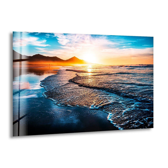 Landscape glass wall art of beach at sunset and waves with blue sky and gold tones is ocean sunset decor for any decor