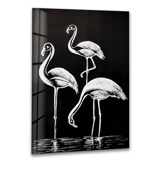 Black and white glass wall art featuring three elegant flamingos standing by reflective water.