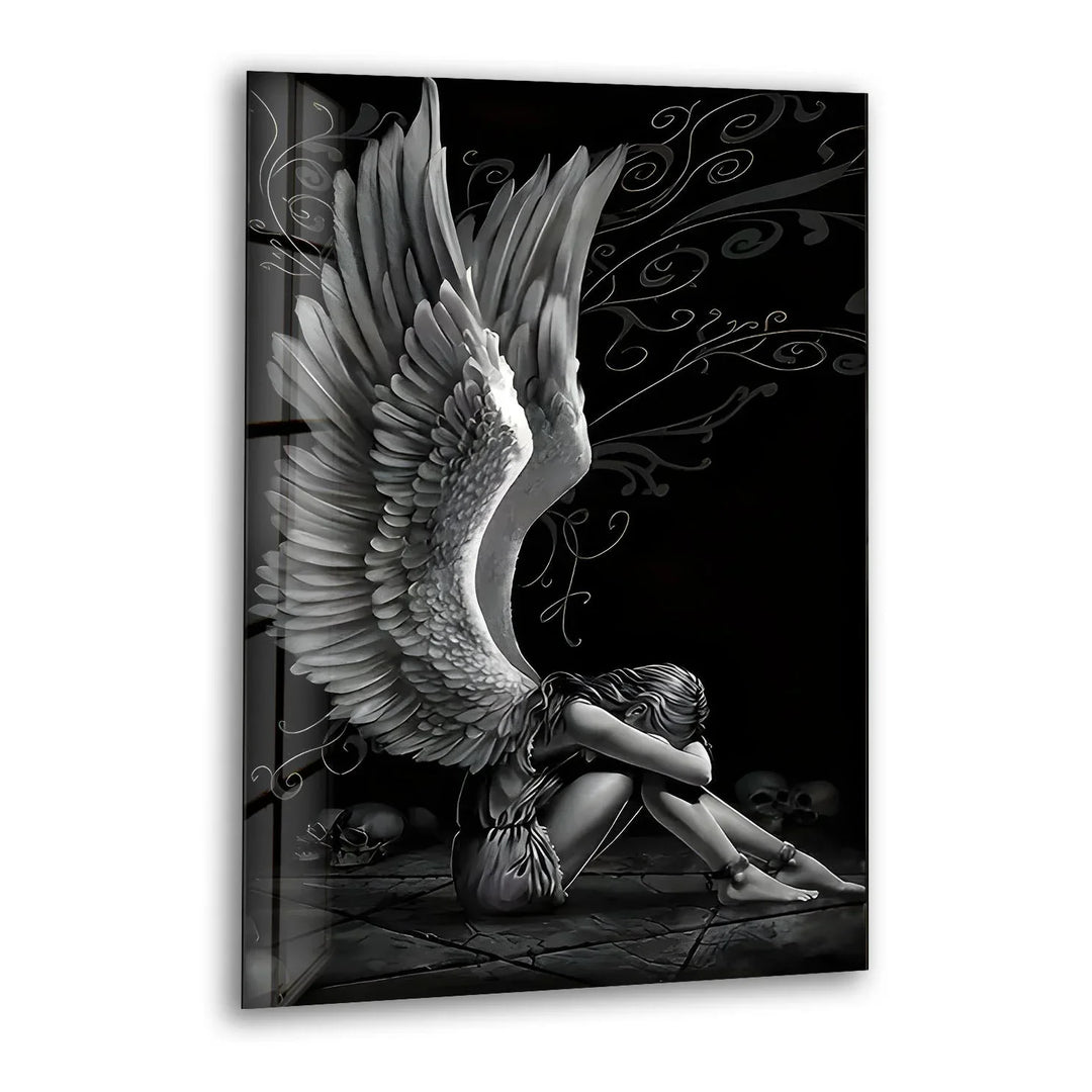 Black and white glass wall art featuring a sorrowful angel with large detailed wings sitting in a dramatic dark scene.