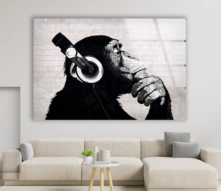 Banksy Dj Monkey Headphones Glass panel art depicting a chimp deep in thought while wearing oversized headphones.