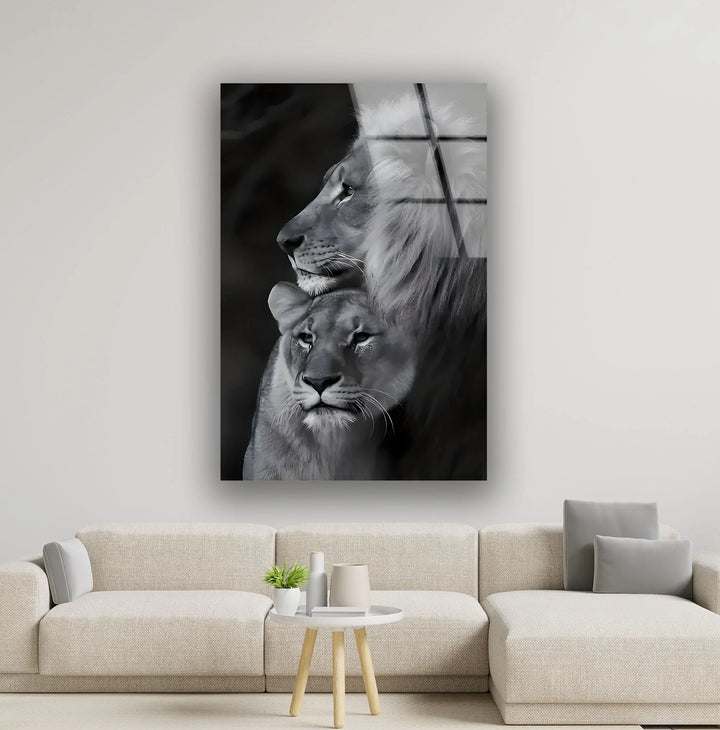 Black and white glass wall art of a majestic lion and lioness resting together in a calm, intimate moment.